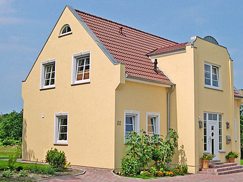 Gelbes Einfamilienhaus von AThoden Bau