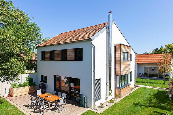 Weißes Einfamilienhaus mit Holzakzenten von Aust-Wimberger