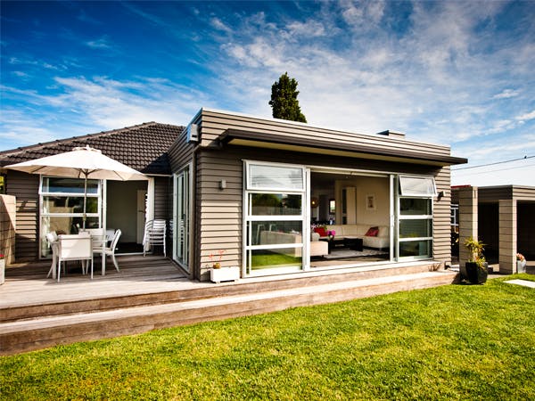 Holzbungalow mit Terrasse und Sonnenschirm