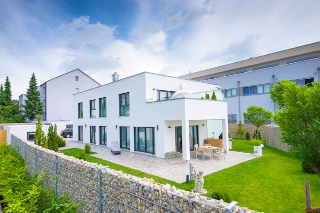 Ein modernes Beispiel für einen Zweifamilienhaus-Grundriss mit übereinander angeordneten Wohneinheiten: Bei diesem Fertighaus im Bauhaus-Stil nehmen die gleichwertigen Wohneinheiten je eine Etage für sich ein. Der große Vorteil hierbei: Die Grundfläche ist nur halb so groß wie bei zwei Einzelobjekten der gleichen Größe, beispielsweise als Bungalows.