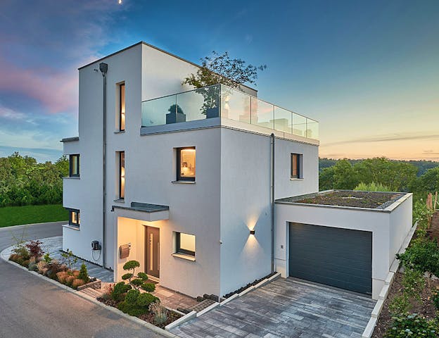 Kubische Villa mit Garage mit ausgefallener Optik, luxuriöser Dachterrasse & verschieden großen Fensterflächen von Fertighaus WEISS