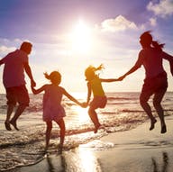 Familie springt am Strand