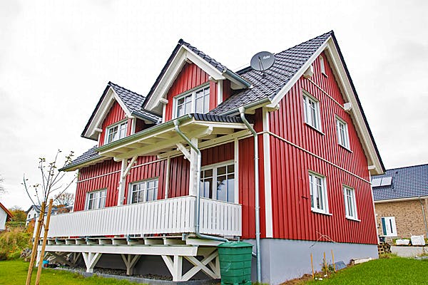 Einfamilienhaus mit roter Holzfassade von Hausbau Heggemann