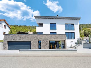 Fertighaus Hanghaus Grossmann mit begrünter Dachterrasse von MYMassivhaus, Pultdachhaus Außenansicht 2