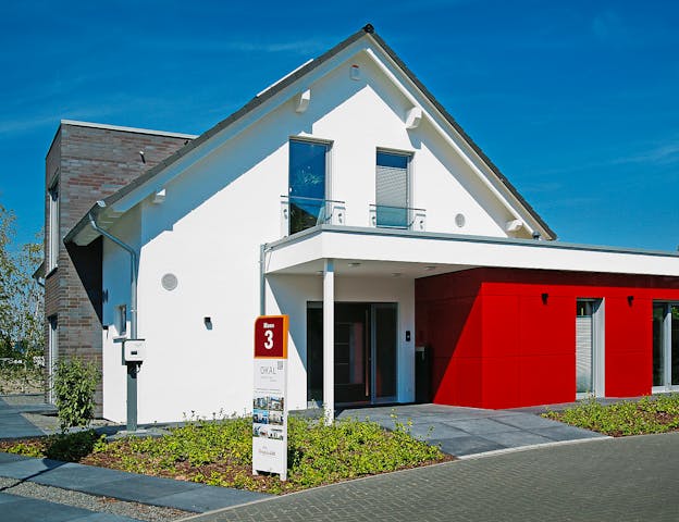 Musterhauspark nahe Bremen: Modernes Satteldach-Fertighaus mit PV-Anlage, verklinkertem Standerker & Einliegerwohnung von OKAL Haus in der FertighausWelt Hannover/Langenhagen
