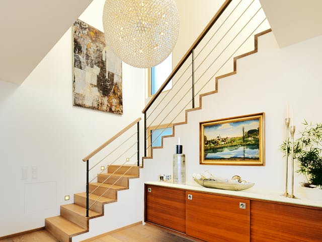 Großer Flur mit Treppe zur Galerie und Designerlampe