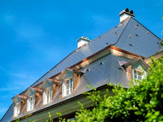 Haus mit Schieferdach und Kupfergauben