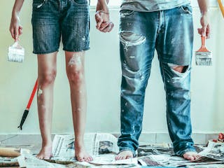 Paar mit Werkzeugen und Arbeitsoveralls