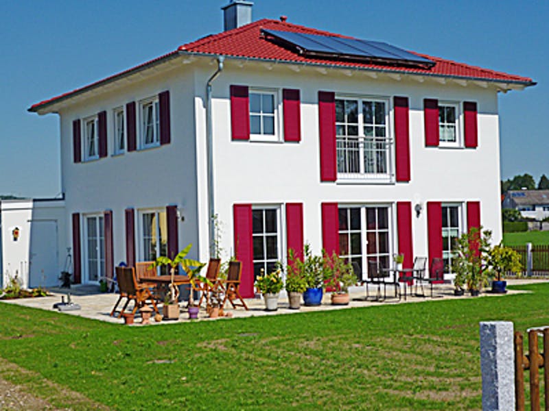 Weiße Stadtvilla mit roten Fensterläden von Rothdach