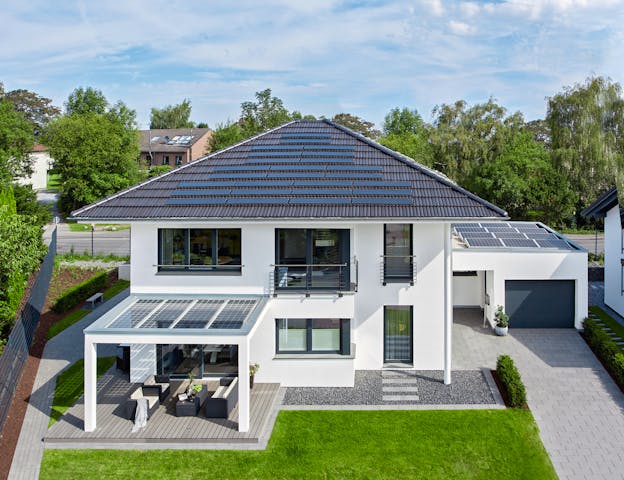 Stadtvilla mit Garage, Terrasse und weißer Edelputzfassade von WeberHaus