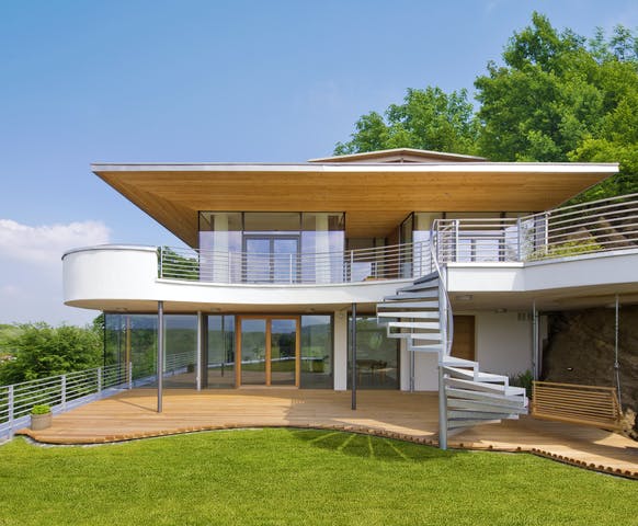Futuristische Villa mit attraktivem Einsatz des Traditionsbaustoffs Holz auf drei Ebenen und aus dem Rahmen fallender Formgebung von Bau-Fritz