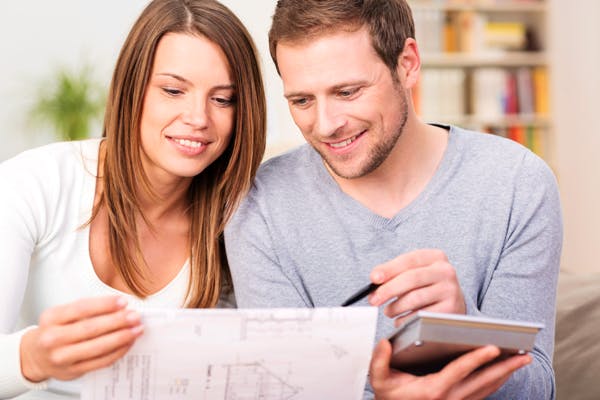 Junges Paar studiert den Bauplan ihres Hauses