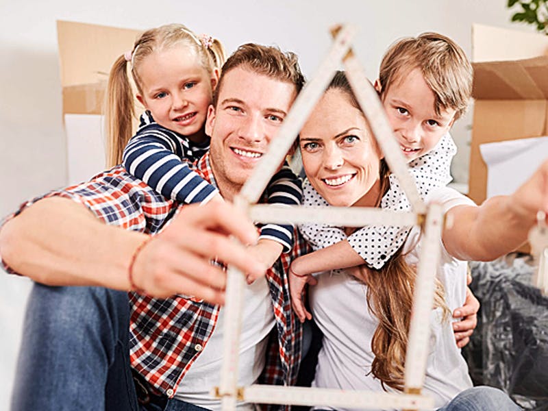 Junge Familie mit Zollstock und Schlüssel